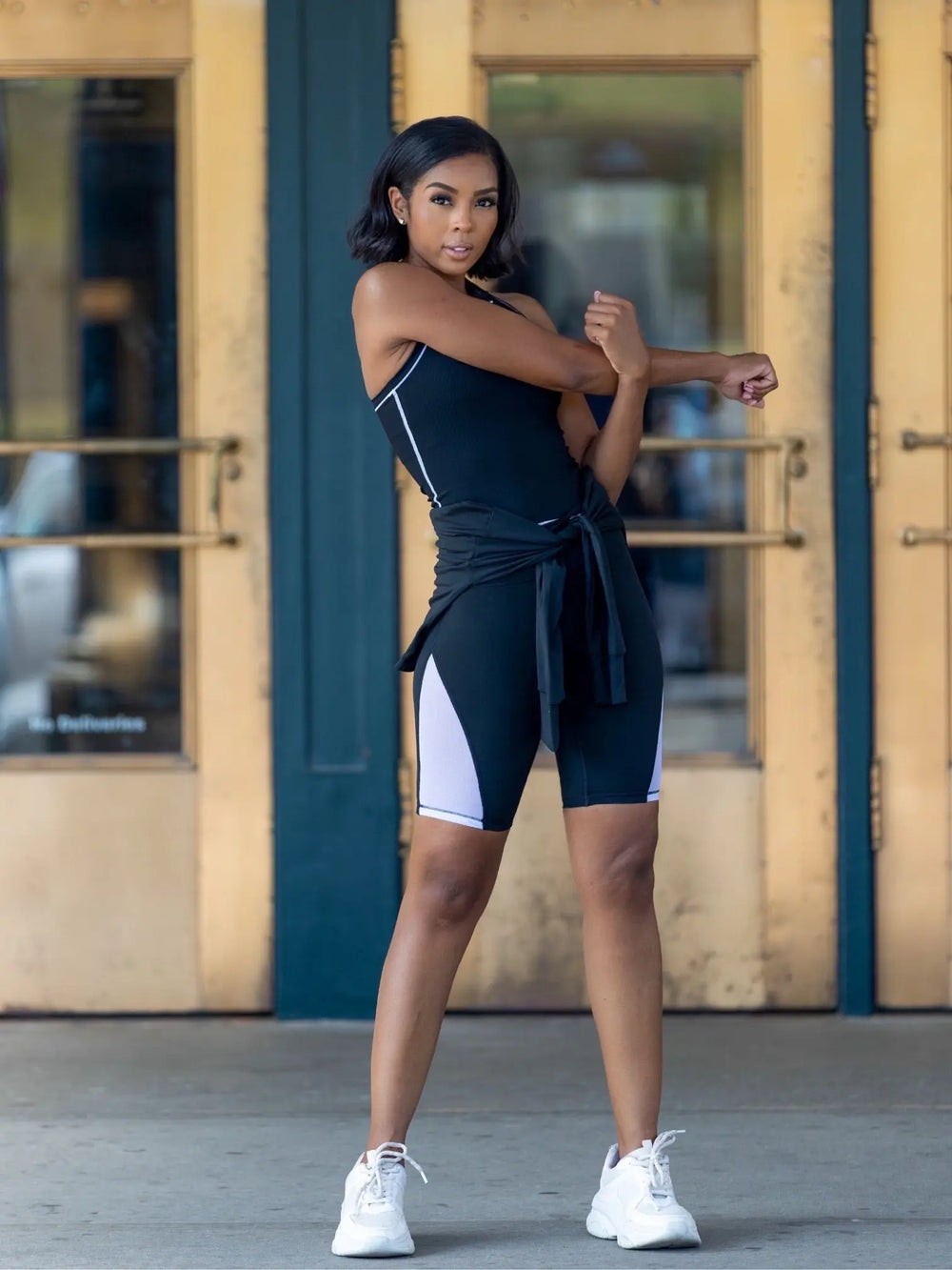 Model wearing the Fit Brit Aire Biker Short in black with white mesh panels active shot